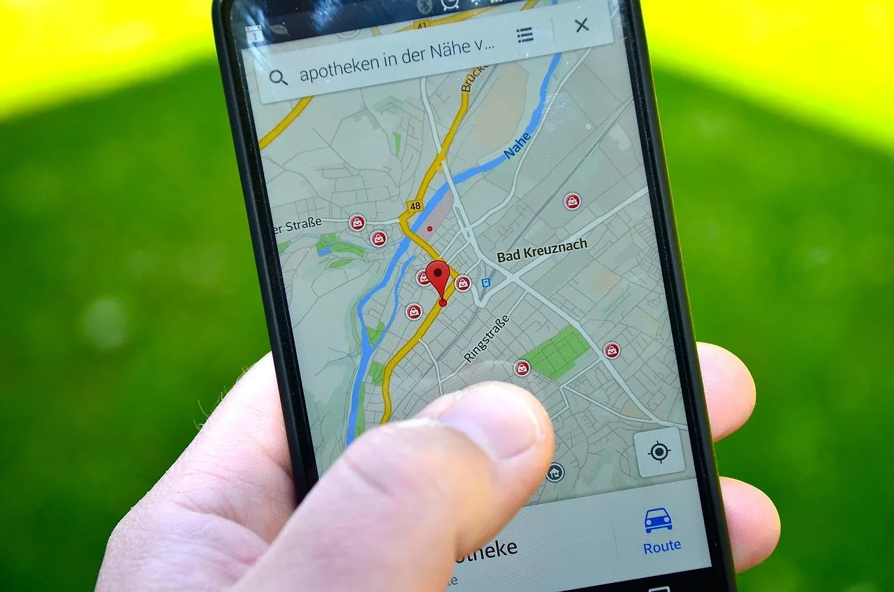 Hand hält ein Smartphone mit Kartenansicht von Bad Kreuznach, roter Standortmarker und Suche nach Apotheken in der Nähe