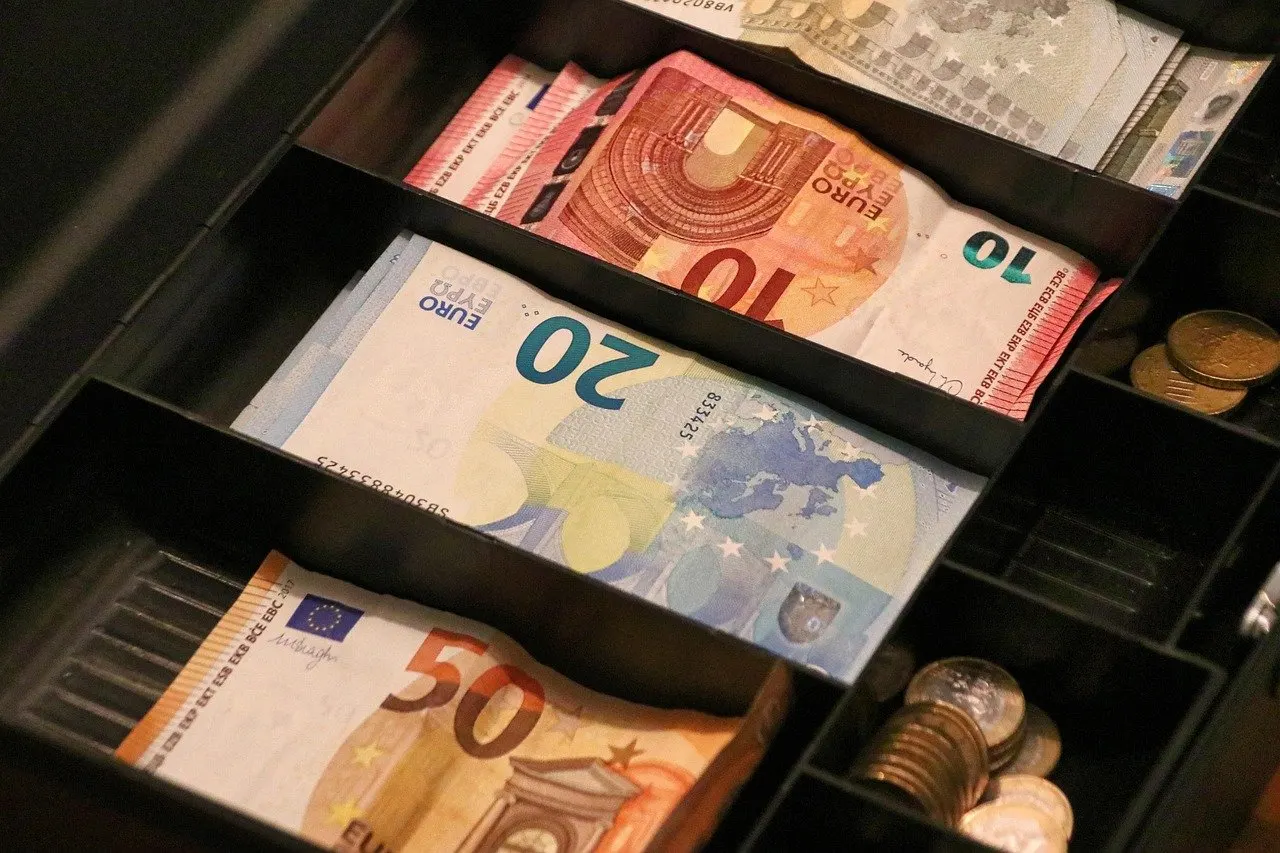 Geöffnete Kassenschublade mit sortierten Euro-Scheinen zu 50, 20 und 10 Euro sowie Münzen in den Fächern rechts